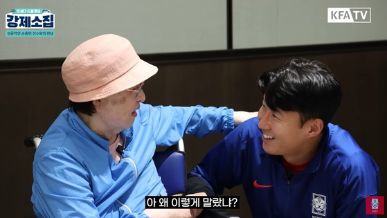 Son Heung-min, right, shakes hands with fan Jung Keum-nam in a video shared on the Korea Football Association's YouTube channel on Tuesday. [SCREEN CAPTURE]
