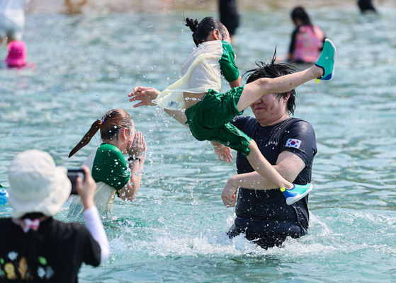 A father and daughter enjoy the outdoor pool of the Jamsil Hangang Park in Songpa District, southern Seoul, during the pool’s opening event held on Wednesday, one day prior to the official opening of six river park pools run by the Seoul Metropolitan Government. [YONHAP] 