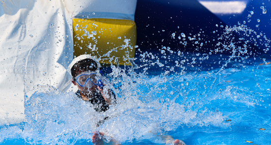 A child comes down a water slide at an outdoor pool at the Jamsil Hangang Park in Songpa District, southern Seoul, during the pool’s opening event held on Wednesday, one day prior to the official opening of six river park pools run by the Seoul Metropolitan Government. [YONHAP] 