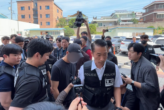 A first lieutenant wearing a ball cap, suspected of being involved in the death of a trainee soldier, heads toward the Chuncheon District Court in Gangwon for a hearing session to assess the ligitimacy of an arrest warrant on Friday. [YONHAP]