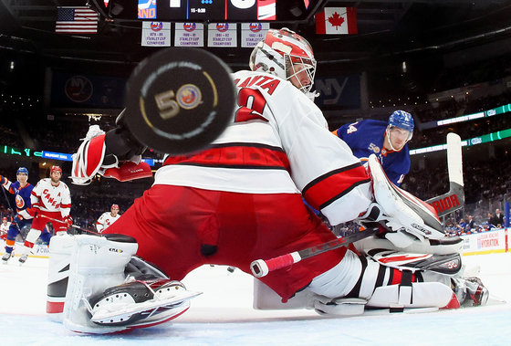Bo Horvat of the New York Islanders scores a third period goal against Antti Raanta of the Carolina Hurricanes during Game Four in the First Round of the 2023 Stanley Cup Playoffs at the UBS Arena in Elmont, New York on April 23, 2023 in this photo by Bruce Bennett. This image topped the Hockey category at the 2024 World Sports Photography Awards.  [BRUCE BENNETT]