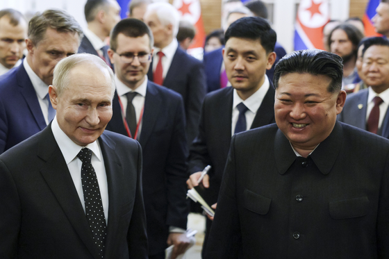 Russian President Vladimir Putin, left, and North Korean leader Kim Jong-un smile as they take a walk together after a summit in Pyongyang on Wednesday. [AP/YONHAP]