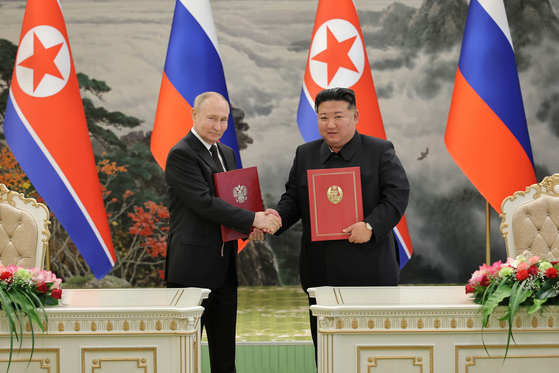 Russian President Vladimir Putin, left, and North Korea's leader Kim Jong Un pose for a photo during a signing ceremony of the new partnership that includes a vow of mutual aid if either country is attacked in Pyongyang, North Korea, on June 19. [NEWS1]