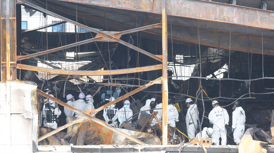 Firefighters and forensic workers conduct a joint investigation on Tuesday at a lithium battery plant in Hwaseong, Gyeonggi, where a fire broke out on Monday, resulting in 23 deaths. [JOONGANG ILBO]