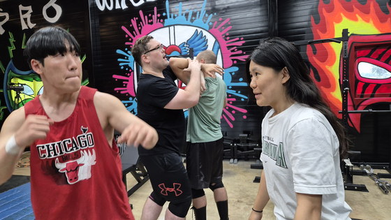 Mary, right, prepares to take a punch as a trainee receives hands-on guidance from a pro. [PWS KOREA]