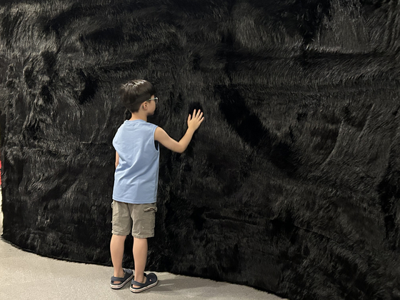 d'strict CEO Lee Sung-ho's young son strokes the wall in ″Tactile Orchestra″ (2018) by Fillip Studios during a press conference for the ″reSOUND″ exhibition at Culture Station Seoul 284 in central Seoul in June. [SHIN MIN-HEE]