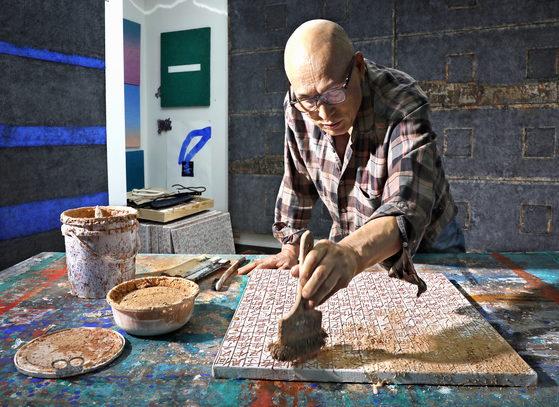 Since Shin uses Chinese letters from Jikji, the world’s oldest known publication with the use of movable metal type, as the main motif for his works, he is often dubbed a Jikji artist. After writing letters on the canvas, he paints a mixture of clay and water over the letters. [PARK SANG-MOON] 