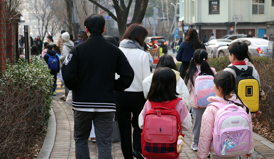 Several elementary school students head to their school in Seoul in March. [NEWS1] 