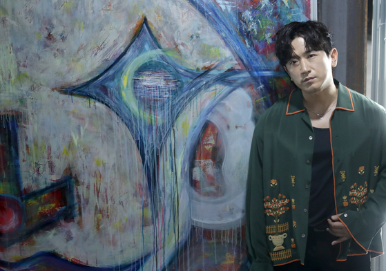 Singer Lee Min-woo of K-pop band Shinhwa poses in front of his work during a press conference held on July 3 at the opening of the ″bbuck on & off″ exhibition in Itaewon, central Seoul. [ARTVERSE]