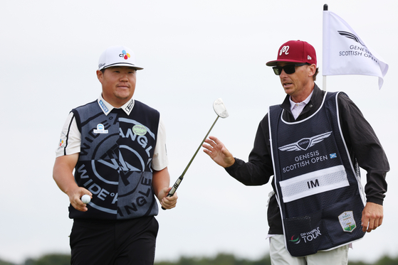 Im Sung-jae passes his putter to his caddie, William Wilcox, on the eighth green during day four of the Genesis Scottish Open at The Renaissance Club in North Berwick, Scotland on Sunday.  [GETTY IMAGES]