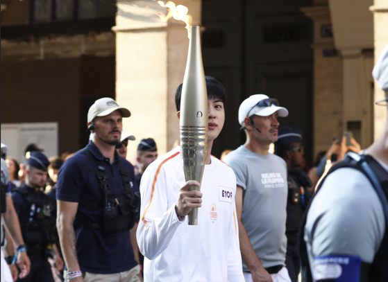 Jin carries the Olympic torch in Paris on July 14. [NEWS1]