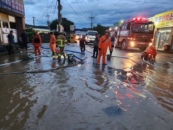 Firefighters and local officials conduct repair work in Haenam County, South Jeolla, as the streets are flooded on Tuesday morning following monsoon rains since the previous day. The overnight downpour flooded nine houses in two villages in the county that received 131 millimeters (5.15 inches) of rain from 5 p.m. Monday to 12 p.m. Tuesday. [NEWS1]