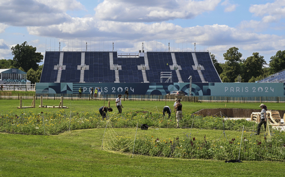 Staff members arrange the landscape at the equestrian arena at the Chateau de Versailles near Paris on July 17. [XINHUA/YONHAP]
