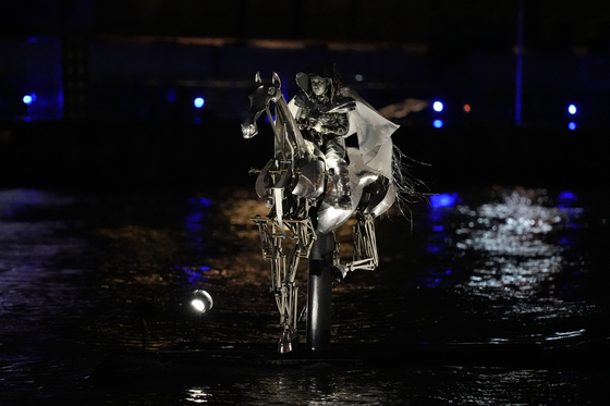 The Olympic flag is carried on horseback down the Seine in Paris on Friday.  [AP/YONHAP]