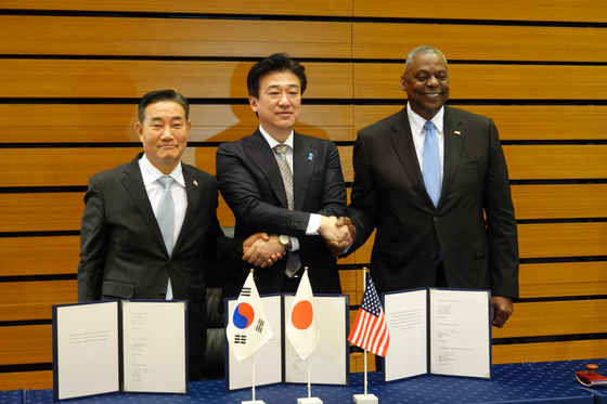 From left, South Korean Defense Minister Shin Won-sik, U.S. Defense Secretary Lloyd Austin and Japanese Defense Minister Minoru Kihara pose for a photo after signing a memorandum of cooperation on the Trilateral Security Cooperation Framework in Tokyo on Sunday. [YONHAP]