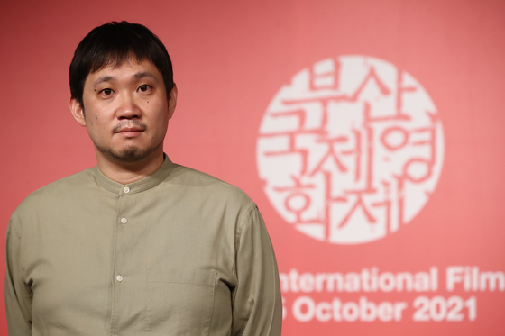 Japanese filmmaker Ryusuke Hamaguchi poses for photos after a press event at KNN Theater in Busan on Oct. 8. [YONHAP] 
