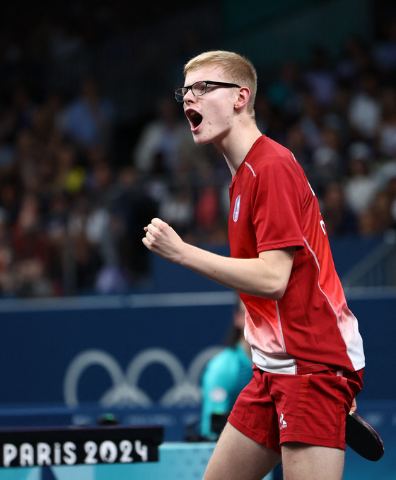Felix Lebrun of France celebrates after winning his round of 64 table tennis match against Harmeet Desai of India in Paris on Sunday.  [REUTERS/YONHAP]