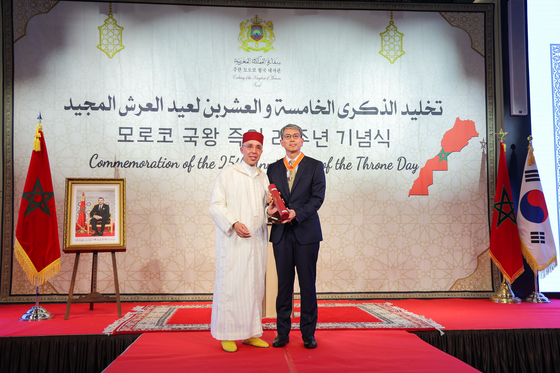 Chung Kee-yong, right, Korea's Special Representative for Indo-Pacific, receives a medal from the King of Morocco for his efforts in enhancing Korea-Morocco relations during the "Commemoration of the 25th Anniversary of the Throne" event at the Ambassador Seoul Pullman Hotel in central Seoul on Tuesday evening. [EMBASSY OF THE KINGDOM OF MOROCCO TO THE REPUBLIC OF KOREA]