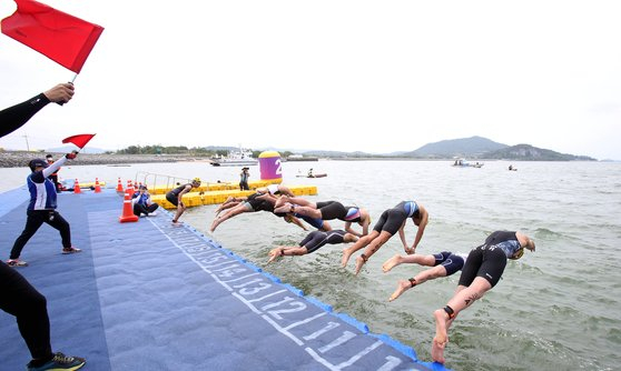 Swimmers dive into water at the 53rd National Junior Sports Festival Triathlon held in Muan County, North Jeolla, in May. [NES1]