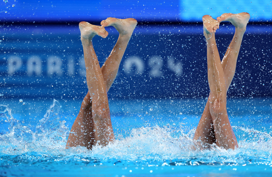 Liuyi Wang of China and Qianyi Wang of China perform in the artistic swimming duet technical routine in Paris on Friday.  [REUTERS/YONHAP]
