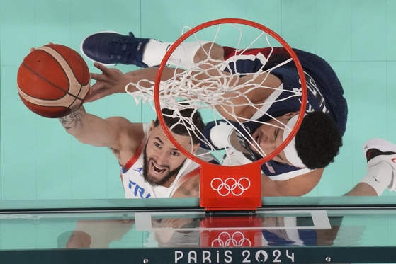 Isaia Cordinier (8), of France shoots past United States' Devin Booker (15) during a men's gold medal basketball game at Bercy Arena at the Paris Olympics on Saturday in Paris. [AP/YONHAP]