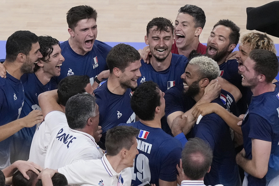 The French men's volleyball team celebrates winning gold against Poland at the Paris Olympics on Saturday in France. [AP/YONHAP]