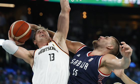 Moritz Wagner of Germany, left, and Nikola Jokic of Serbia vie for the ball during the men's basketball bronze medal game at the South Paris Arena in Paris on Saturday. [EPA/YONHAP]