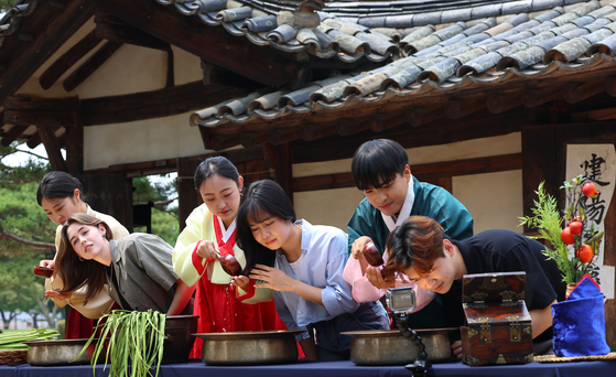 Students from overseas experience the traditional way of washing hair at The National Folk Museum of Korea in Jongno District, central Seoul, on June 5, 2024. [YONHAP] 
