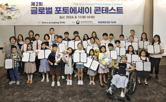 Choi Ji-young, executive editor of the Korea JoongAng Daily, second row, far left, and winners of the Korea JoongAng Daily's second Global Photo Essay Contest pose for a photo while holding their awards at the JoongAng Ilbo building in Mapo District, western Seoul, on Saturday. [PARK SANG-MOON]