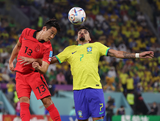 Korea's Son Jun-ho, left, vies for the ball with Brazil's Lucas Paqueta during a 2022 World Cup round of 16 match at Stadium 974 in Doha, Qatar on Dec. 6, 2022. [YONHAP]