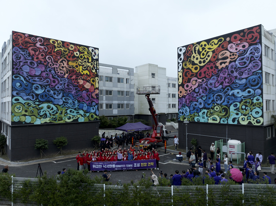 JonOne and the residents of Shinan County, South Jeolla, pose together for a photograph in front of the graffiti artist's work at the Palace Park apartment complex on July 6. [URBAN BREAK]