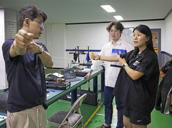Zachary, left, emphasizes the importance of keeping one's arm straight and extended. [PARK SANG-MOON]