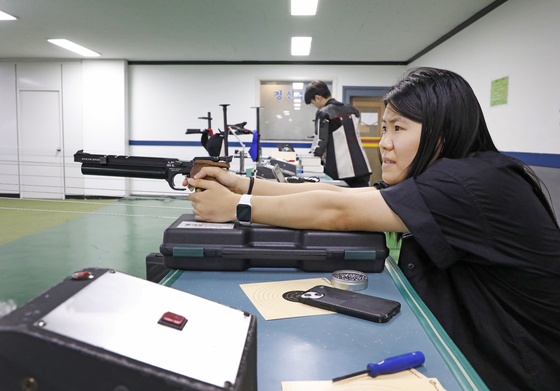 Mary checks her shot and struggles to see if it landed on the target. [PARK SANG-MOON]