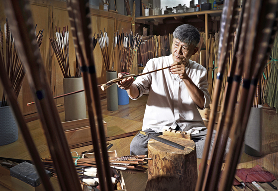 Yoo Se-hyun, an intangible cultural asset for his skills in making traditional arrows, checks on the shaft to see whether the shaft is twisted or not at his studio located in Young Jip Bows & Arrows Museum in Paju, Gyeonggi. [PARK SANG-MOON] 