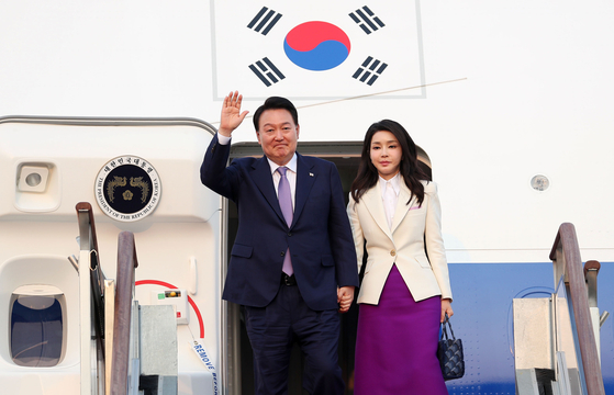 President Yoon Suk Yeol, left, waves next to first lady Kim Keon-hee from the presidential jet at Seoul Air Base in Seongnam, Gyeonggi, after wrapping up a six-day trip to Paris and Hanoi on June 22. [JOINT PRESS CORPS]