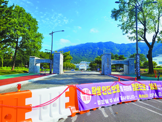 A sign reads that Changwon National University will be restricting access of cars through its main gate. [JOONGANG ILBO]