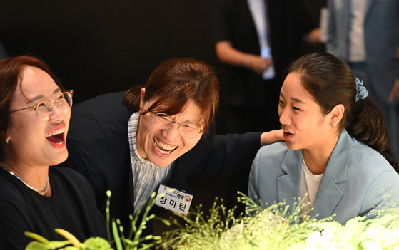 Second Vice Minister of Culture, Sports and Tourism Jang Mi-ran, center, chats with badminton player and Olympic medalist An Se-young, right, at an event celebrating athletes who participated in the 2024 Paris Olympics in Seoul Thursday. [JOINT PRESS CORPS] 