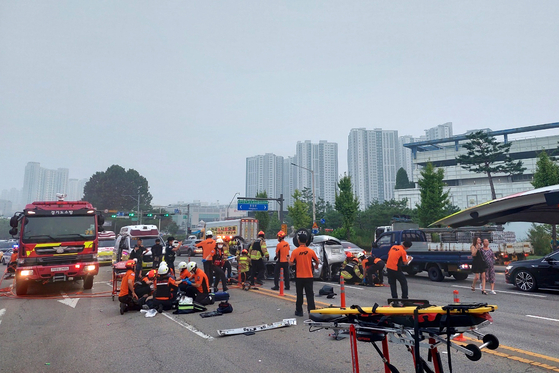 Fire authorities carry out a rescue operation at a site of a traffic accident at an intersection in Ansan, Gyeonggi, on Saturday. A van carrying day laborers collided with a bus, resulting in five deaths. [NEWS1]