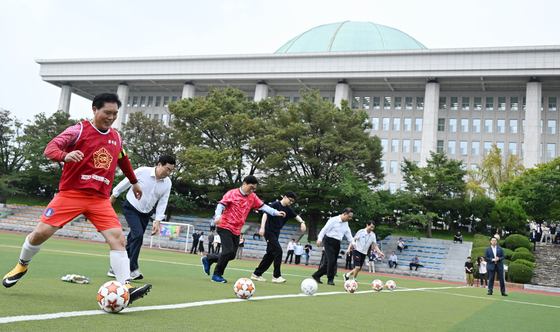 Putting aside their differences, bipartisan lawmakers take part in a friendly football match held at a field in front of the National Assembly in Yeouido, western Seoul, on Monday. From left, People Power Party (PPP) Rep. Song Seog-jun, Democratic Party floor leader Park Chan-dae, National Assembly Speaker Woo Won-shik, People Power Party Chairman Han Dong-hoon and National Assembly Vice Speaker Joo Ho-young, get ready to start a match. [JOINT PRESS CORPS]