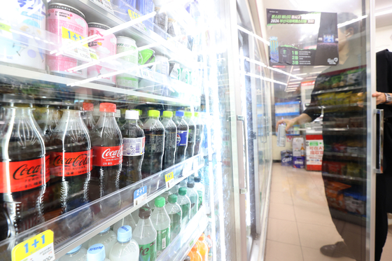A customer picks out a beverage at a convenience store in Seoul on Monday. [YONHAP]