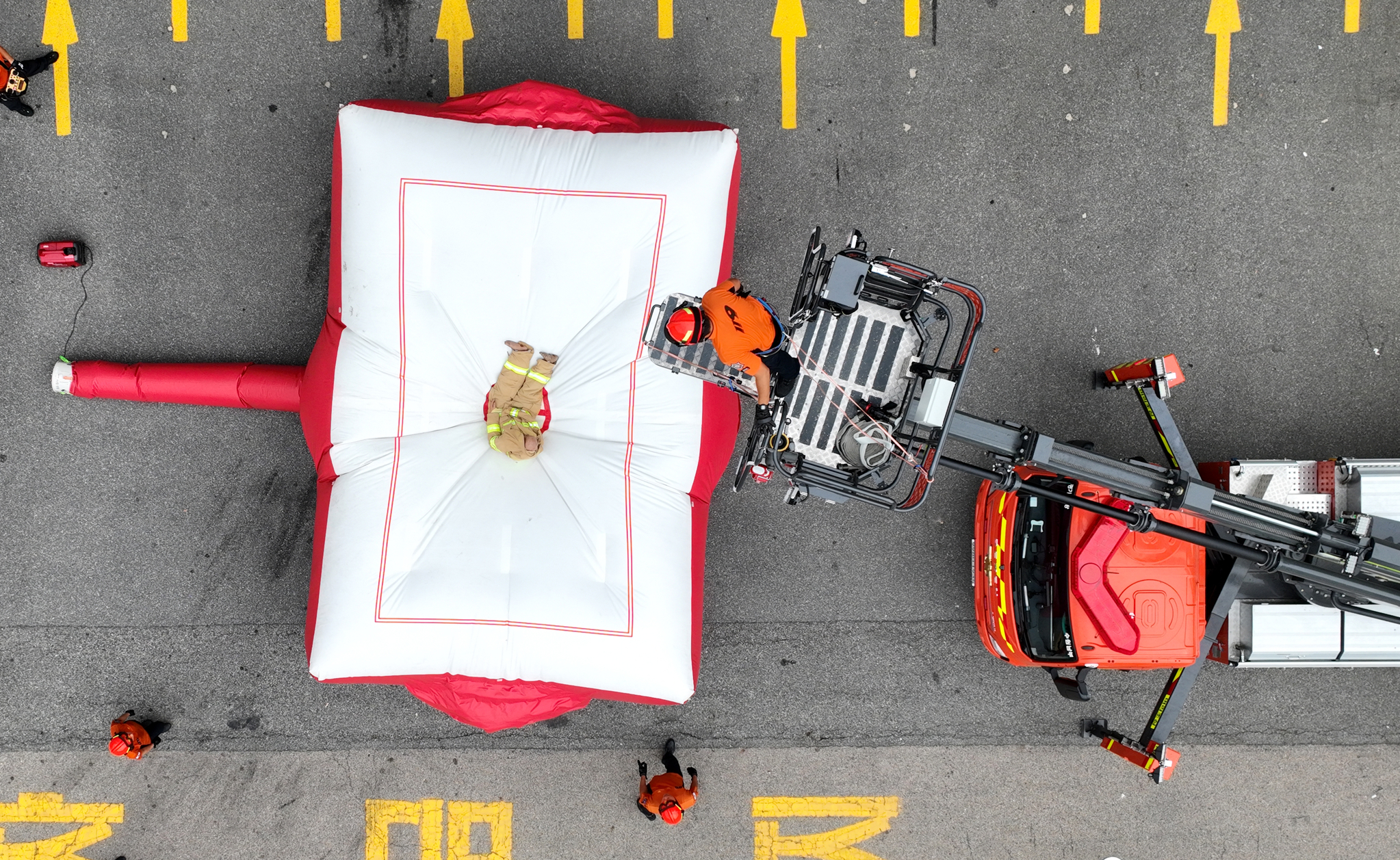 Fire authorities conduct a drill involving landing on an inflatable fire rescue mattress at the Gyeonggi Fire and Disaster Headquarters in Gwonseon District, Gyeonggi, on Monday. Concerns rose over the safety of firefighters' rescue mattresses after it was revealed that two of the seven victims in Thursday's Bucheon hotel fire died after jumping onto one while trying to escape. [JOINT PRESS CORPS]
