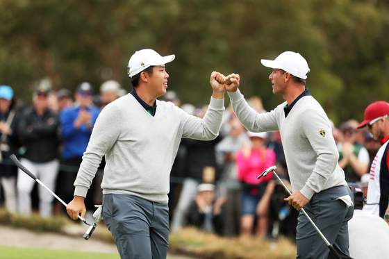 This file photo shows Adam Scott and An Byeong-hun react on the 17th green during day three of the 2019 Presidents Cup at Royal Melbourne Golf Course in Melbourne on Dec. 14, 2019.  [GETTY IMAGES]