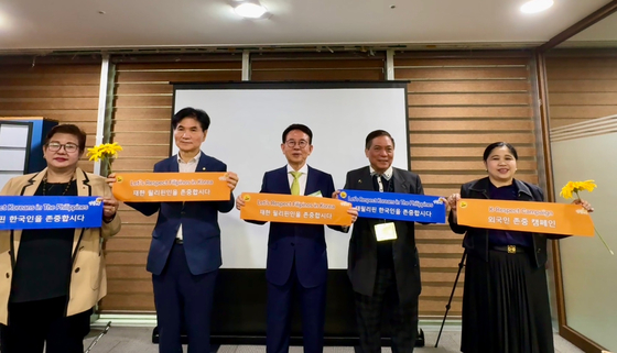 From left, Philippine Chamber of Commerce and Industry President Nina Mangio, Democratic Party Rep. Lee Yong-sun, Sunfull Foundation Chairman Min Byoung-chul, Philippines-Korea Economic Council President Robert Yupangco and Philippine Ambassador to Seoul Theresa Dizon-De Vega hold banners promoting respect for Filipinos in Korea and Koreans in the Philippines during the K-respect campaign event held at the National Assembly compound in Yeouido, western Seoul, on Monday. [SUNFULL FOUNDATION]