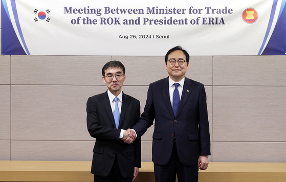 Korea's trade minister, Cheong In-kyo, right, and Economic Research Institute for ASEAN and East Asia chief Tetsuya Watanabe shake hands after a meeting in Seoul on Monday. [MINISTRY OF TRADE, INDUSTRY AND ENERGY]