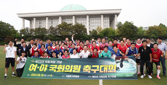 Lawmakers of rival parties take a commemorative photo after a friendly soccer match in front of the National Assembly in Yeouido, western Seoul, on Monday. [YONHAP]