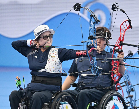 Kim Ok-geum, left, competes in the W1 mixed doubles at the 2022 Hangzhou Asian Para Games in Hangzhou, China on Oct. 26, 2023.  [YONHAP]