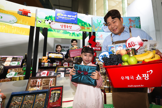  Comedian and television personality Moon Se-yoon presents gift sets for the Chuseok harvest festival holiday with models at the Post Tower in Jung District, central Seoul, on Tuesday. [YONHAP]