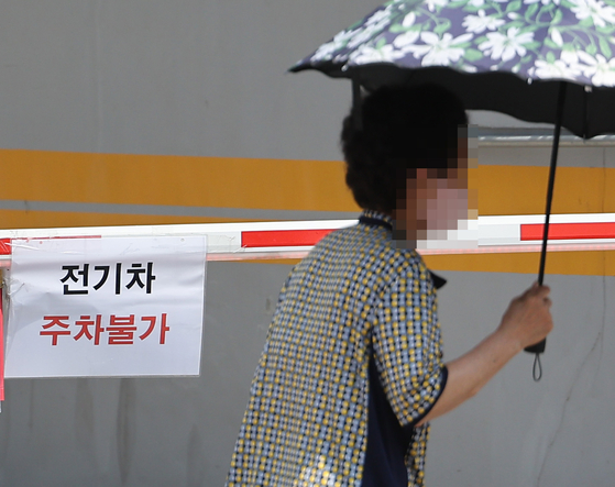 A notice bans EVs from entering underground parking garages in a building in Seoul on Aug. 13. [YONHAP] 