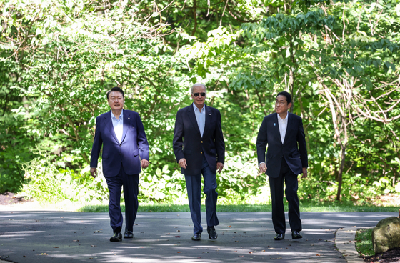 From left, Korean President Yoon Suk Yeol, U.S. President Joe Biden and Japanese Prime Minister Fumio Kishida take a walk together after their trilateral summit at Camp David in Maryland on Aug. 18. [YONHAP]