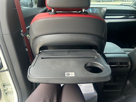 A small table is mounted to the back of the front seats so that passengers in the rear seats can easily get some work done or set up their tablets. [SARAH CHEA] 